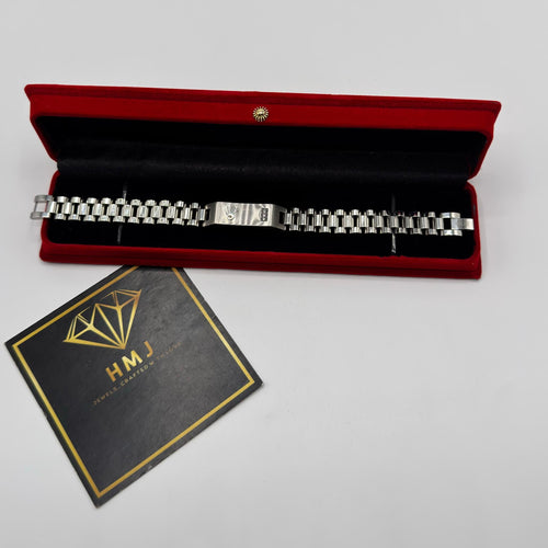 Silver bracelet in a red box with a black card on a white background