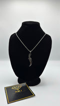 Silver necklace on a black mannequin bust with a branded card below on a white background